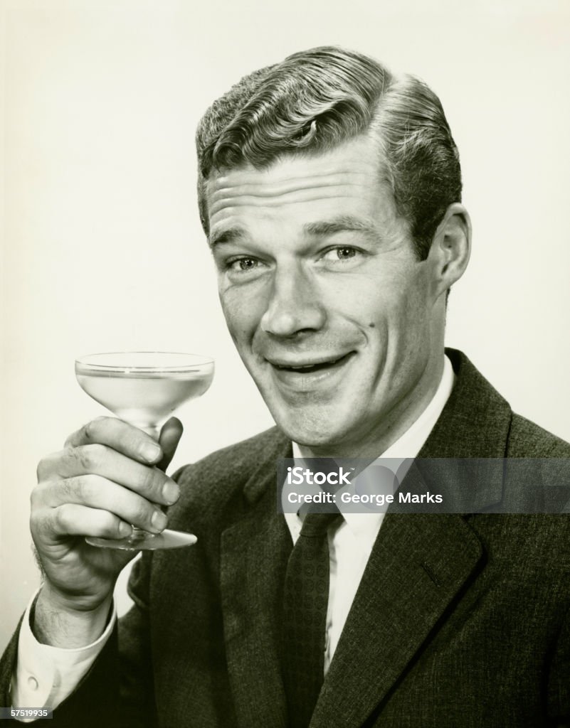 Young businessman holding wine glass, (B&W), portrait  Old-fashioned Stock Photo