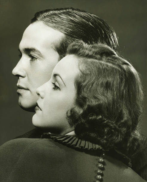 Profiles of couple posing in studio, (B&W), close-up, portrait  slicked back hair stock pictures, royalty-free photos & images