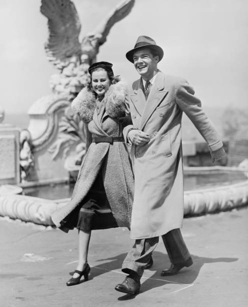 elegante par caminar por el paseo marítimo, (b & p - men fedora hat 1940s style fotografías e imágenes de stock