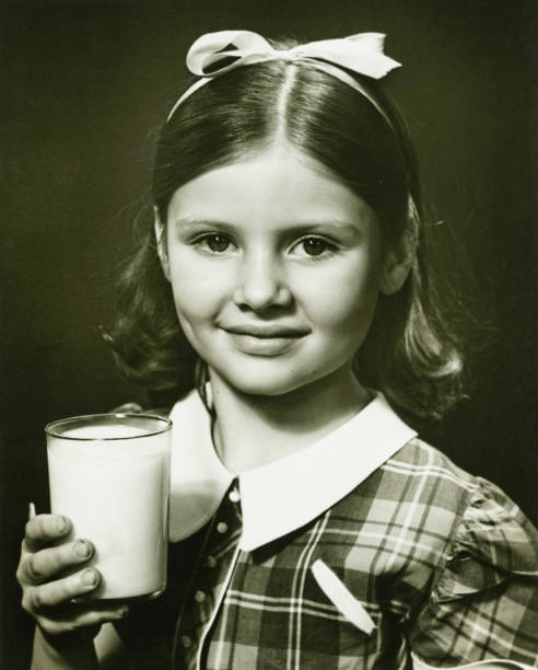 girl （6 ～7 ）保持ガラスのミルク�、スタジオでポーズを取る - children only healthy lifestyle vertical close up ストックフォトと画像