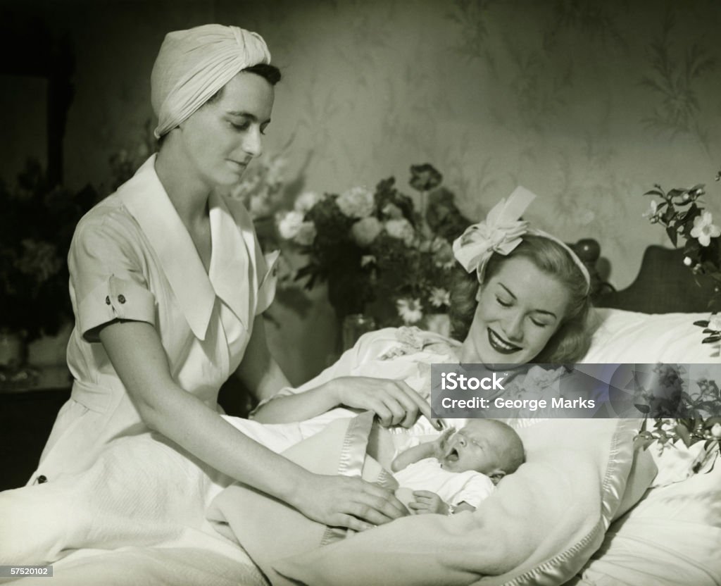 Mère allongé dans le lit de bébé souriant (0-6 mois - Photo de D'autrefois libre de droits