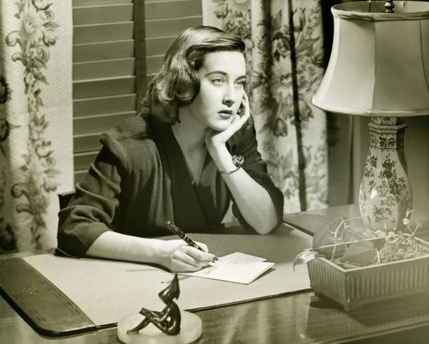 attenta donna scrivendo una lettera su una scrivania, (b & w - anni 40 foto e immagini stock