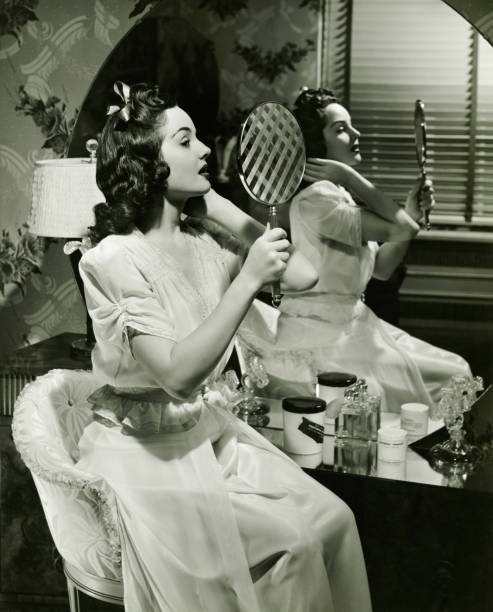 jeune femme examiner maquillage dans le miroir, (b & w - sexy look photos et images de collection