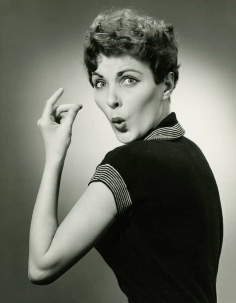 Woman whistling and snapping fingers in studio, (B&W), portrait  whistling stock pictures, royalty-free photos & images