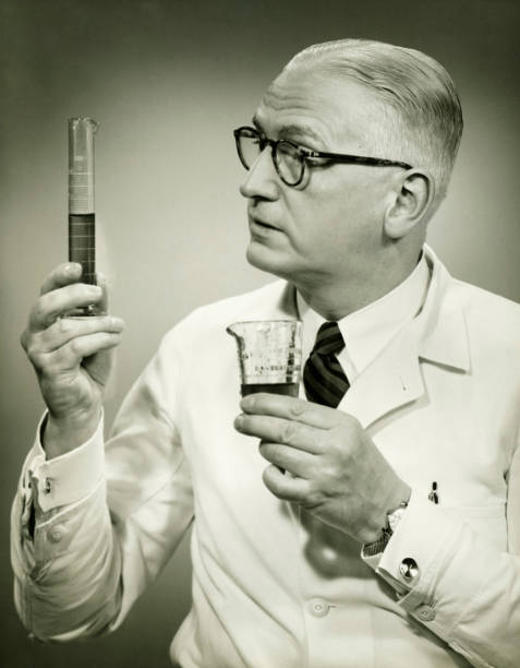Doctor holding buretts in studio, (B&W), portrait  beaker photos stock pictures, royalty-free photos & images