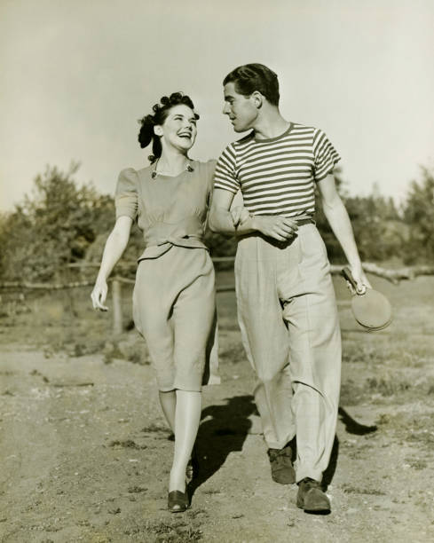 casal jovem passeando em campo de braços dados, & (b w - 1930 - fotografias e filmes do acervo