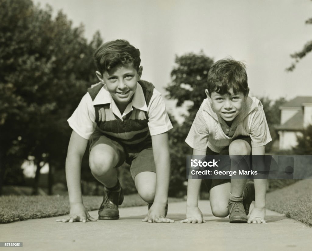 Dois meninos (8 e 9) (12-13) prepare-se para começar a correr, & (B W - Foto de stock de Criança royalty-free