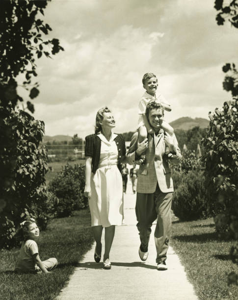 Family with two children (4-5) on walk, (B&W)  20th century photos stock pictures, royalty-free photos & images