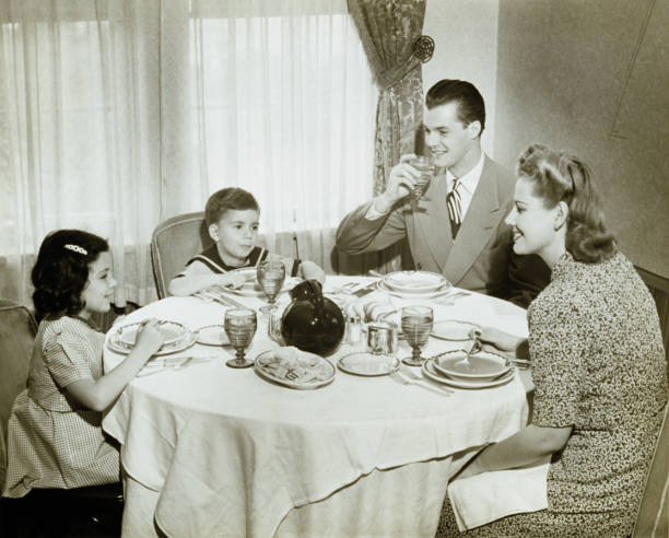 famille assis autour de table, avec repas, les enfants - 40s couple women house photos et images de collection