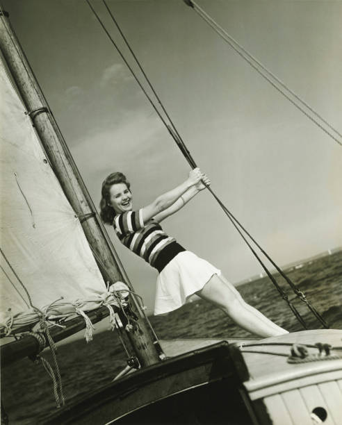 Young woman holding rigging on yacht, (B&W)  yacht photos stock pictures, royalty-free photos & images