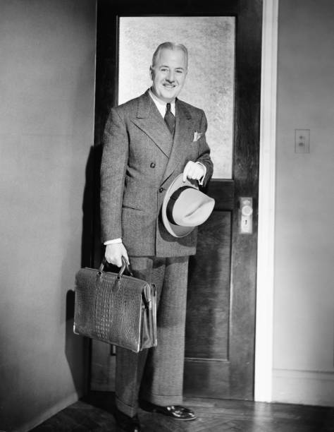 熟年男性ポーズをとるのドアで、ご自宅のリビングルーム（b &w ）、ポートレート - men fedora hat 1940s style ストックフォトと画像