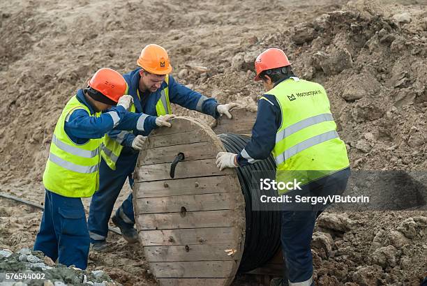 Arbeiter Ziehen Walzenhochspannungskabelleitung Stockfoto und mehr Bilder von Arbeiten - Arbeiten, Baustelle, Biegung