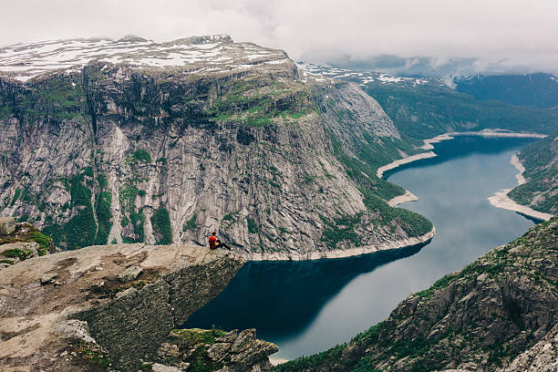istock Man sitting on the edge of Trolltunga 576546246