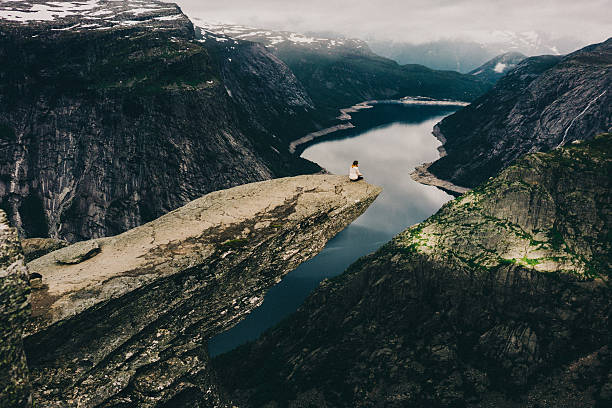 kobieta siedząca na trolltunga - scenics cliff landscape canyon zdjęcia i obrazy z banku zdjęć