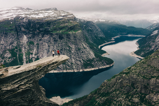 Two  young adults  standing  on the Trolltunga in Norway 