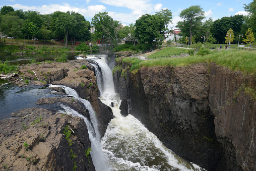 Paterson, USA - May 30, 2016. People enjoy the view of waterfalls at Paterson Great Falls National Historic Park. The park is located in the city of Paterson in Passaic County of New Jersey. Paterson was the first planned industrial city in the the United States and the Great Falls of Passaic River in the park is one of the largest waterfalls east of the Mississippi River.