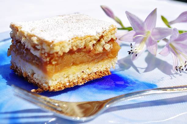 istock Apple pie, fork and violet flower on plate with bluesmudges. 576553598