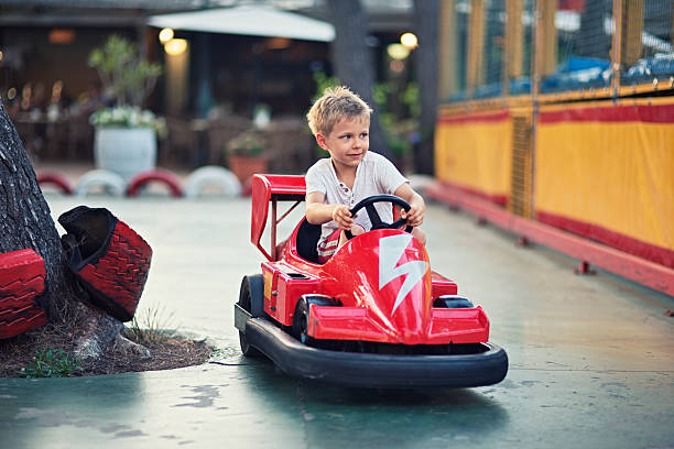 Little boy driving a bumper car at an amusement park.
