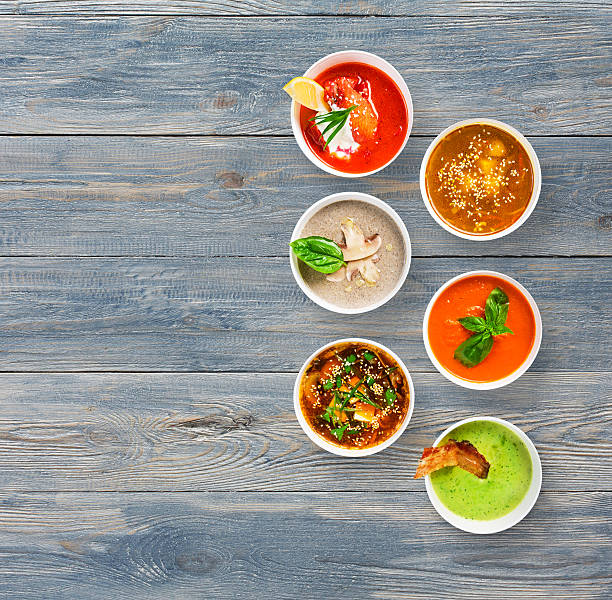 istock Six soups at blue wood, top view with copy space 576554254