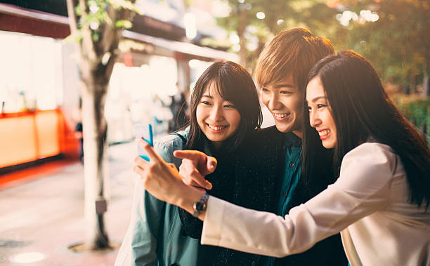 istock Happy japanese friends surfing the net 576554794