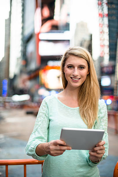 frau mit dem laptop in times square-new york city - digital tablet travel destinations new york state times square stock-fotos und bilder