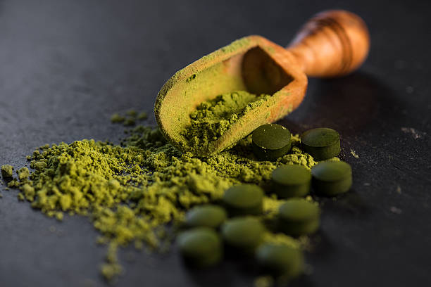 Organic Chlorella Powder and Tablets Organic chlorella powder and tablets shot on a slate  chlorella stock pictures, royalty-free photos & images
