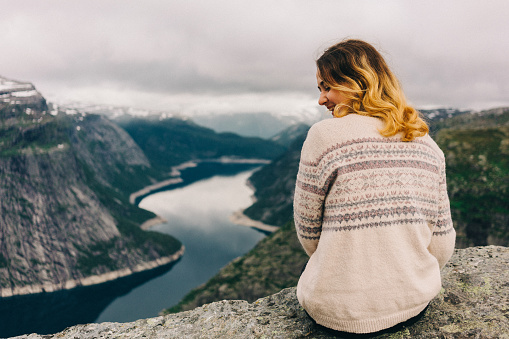 Woman sitting on the Trolltunga in Norway 