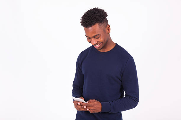 istock Young African American man sending a sms text message 576555560