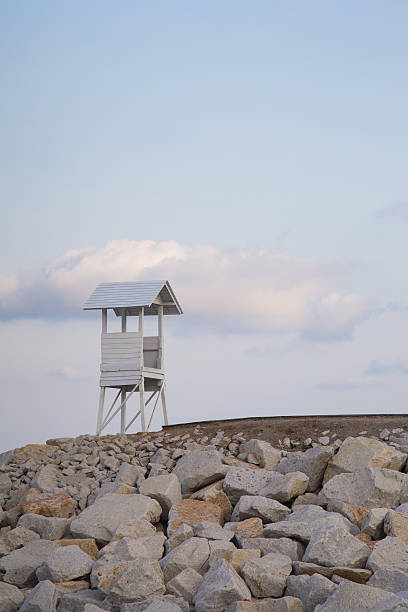 istock Lifeguard stand over rock walkway with natural sky background 576556348