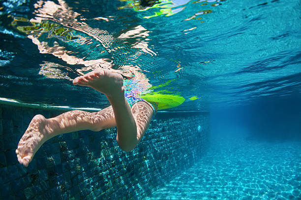 istock Child swimming with fun on yellow ring in blue pool 576557792