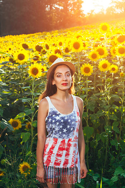 istock Young woman in sunflower field 576559110