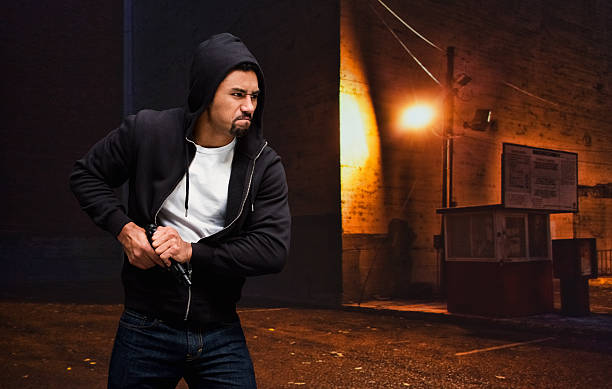 istock Thief in action with gun at night outdoors 576561136