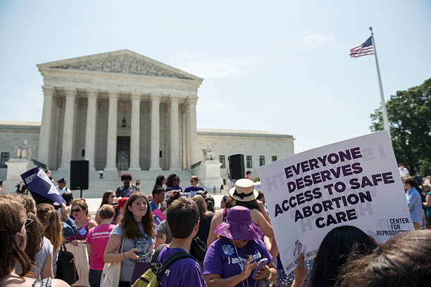 Pro-choice supporters at U.S. Supreme Court Washington DC, USA - June 27, 2016: Pro-choice supporters stand in front of the U.S. Supreme Court after the court, in a 5-3 ruling in the case Whole Woman's Health v. Hellerstedt, struck down a restrictive Texas abortion access law. reproductive rights stock pictures, royalty-free photos & images