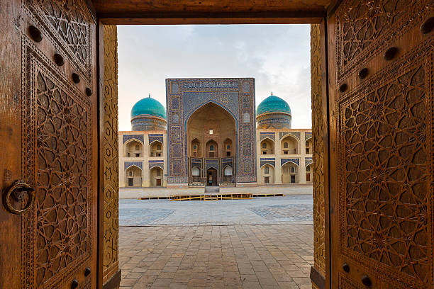 Wooden door open. Blue domes of the Madressa through open wooden door in Bukhara, Uzbekistan. bukhara stock pictures, royalty-free photos & images
