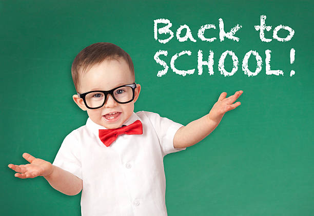 istock Happy smiling little boy on a chalkboard background 576565476