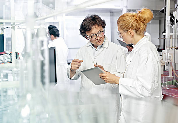 Two Scientists working on computer in a lab stock photo