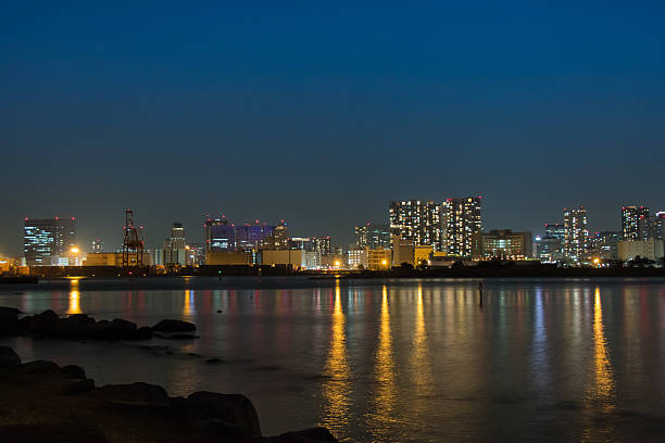 Blur of Night view city with mirror reflection in Tokyo Bay, Tokyo City Skyline background from Rainbow Bridge Odaiba at night, Japan