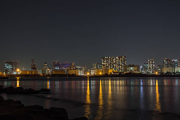 Blur of Night view city with mirror reflection in Tokyo Bay, Tokyo City Skyline background from Rainbow Bridge Odaiba at night, Japan