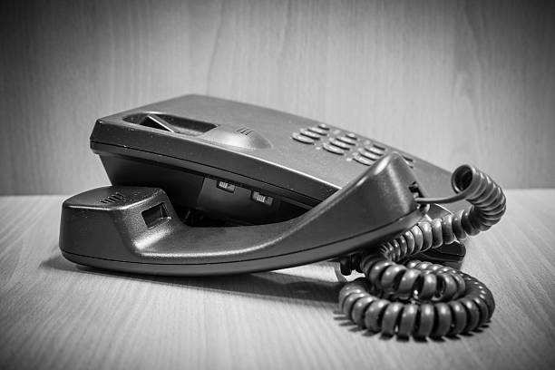 istock Old button telephone on wooden desk 576568818