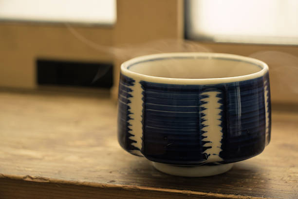 Hot Japan tea cup on wood bar beside window at snowy day, Hokkaido, Japan