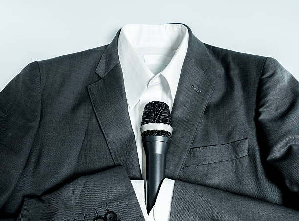 istock Business suits holding microphone 576572712