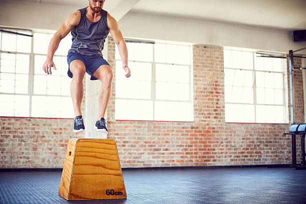 istock Low section of determined athlete doing box jumping at gym 576575368