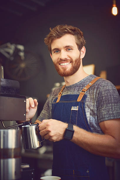 istock Confident barista holding milk jug in cafe 576575624