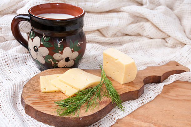 cheese, dill on the board and a jug of milk - кувшин imagens e fotografias de stock