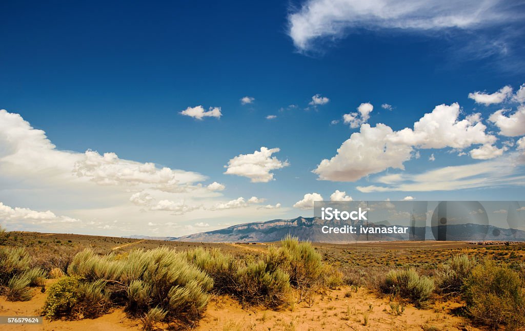Southwestern Sunset Landscape with Sandia Mountains White Fluffy Clouds over Southwest Landscape New Mexico Stock Photo
