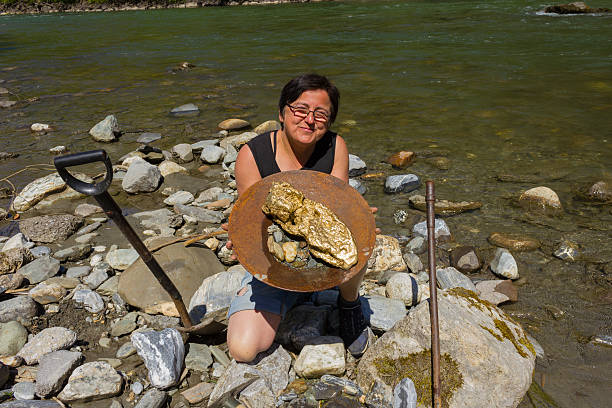 Gold Nugget mining from the River Gold Nugget mining from the River, with a gold pan, and find some big gold nugget. alaska gold rush stock pictures, royalty-free photos & images
