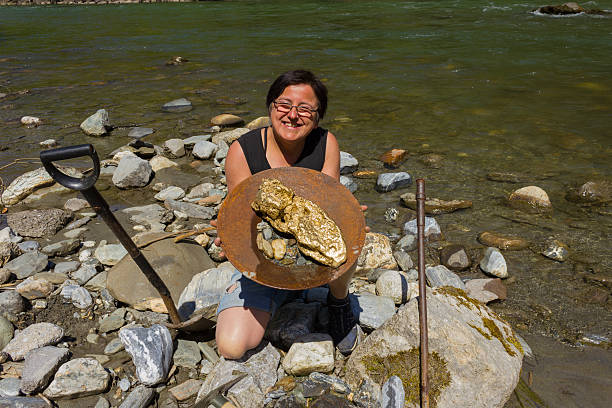 Gold Nugget mining from the River Gold Nugget mining from the River, with a gold pan, and find some big gold nugget. alaska gold rush stock pictures, royalty-free photos & images