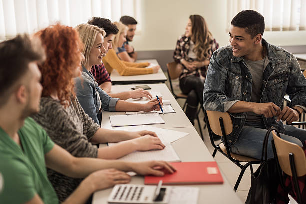 istock Smiling students in the classroom talking to each other. 576583290