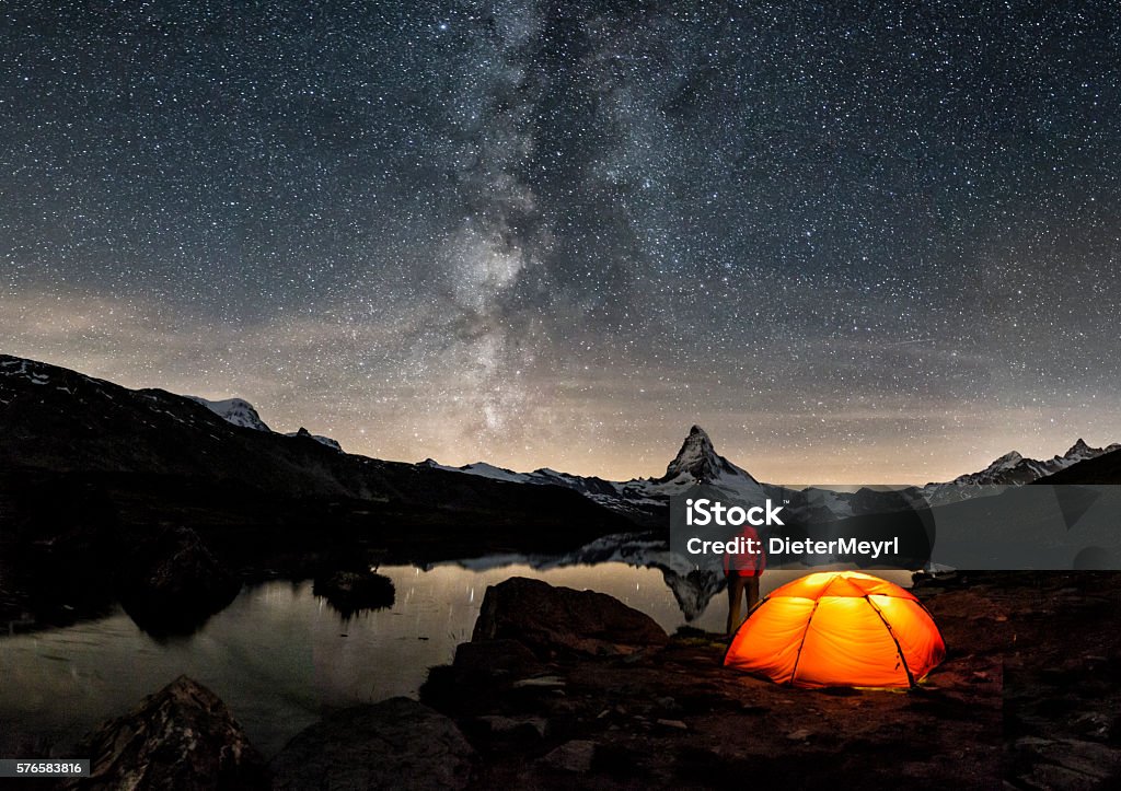 Loneley Camper under Milky Way at Matterhorn An illuminated tent under Milky Way at Matterhorn in Switzerland Camping Stock Photo