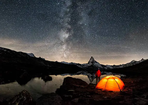 An illuminated tent under Milky Way at Matterhorn in Switzerland